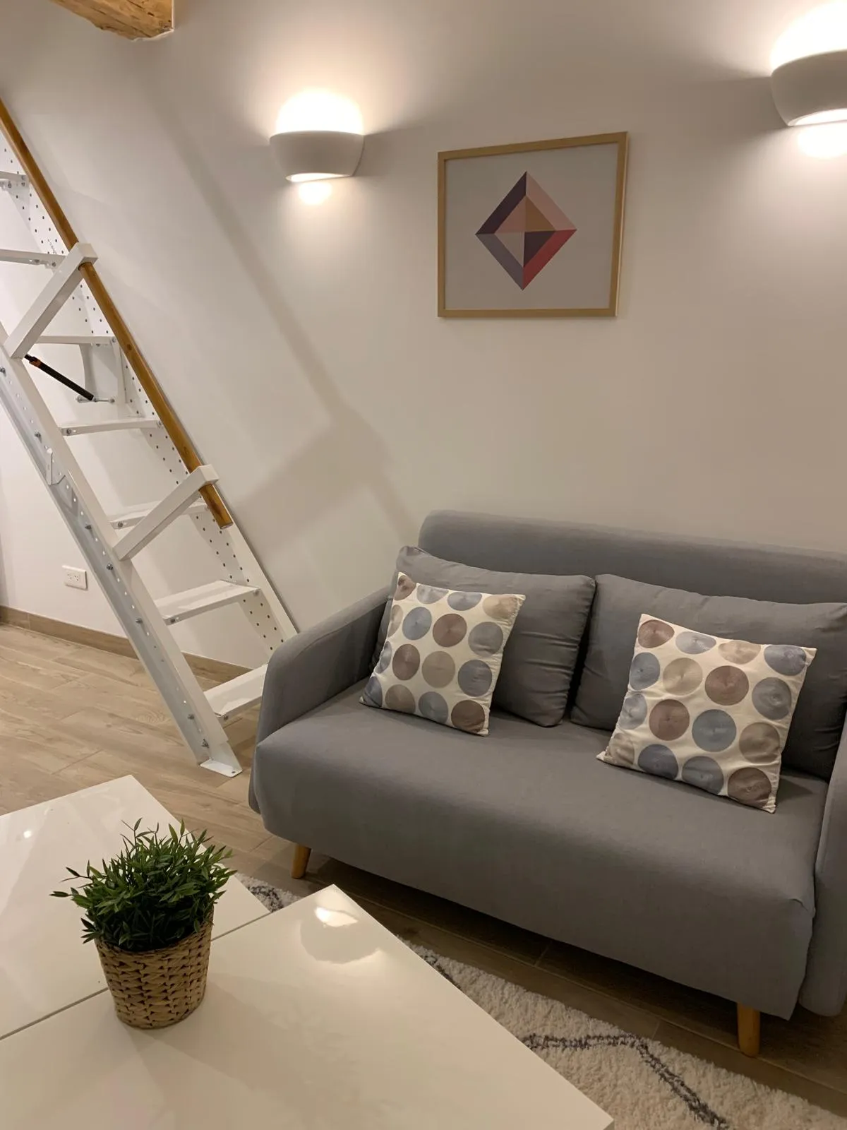 Le salon du petit loft, canapé et échelle de meunier